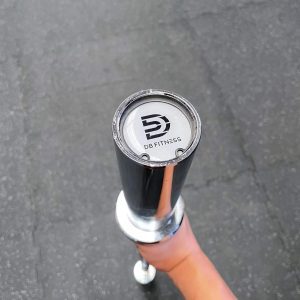 Strength Training Equipment- (300*300) Image- 120cm Olympic Bar supported vertically with hand with DB Fitness Logo visible on the outer side of the sleeve