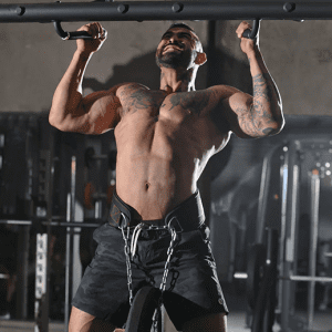 Weight Lifting Gear- View of a man equipped with weight lifting belt with chain and black weight plate attached performing a pullup