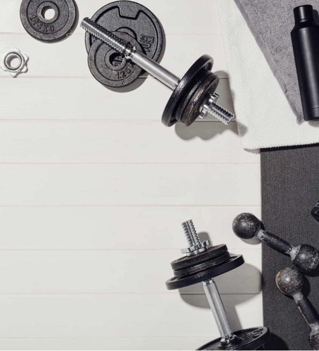 Home fitness equipment including dumbbells, weights, and water bottles