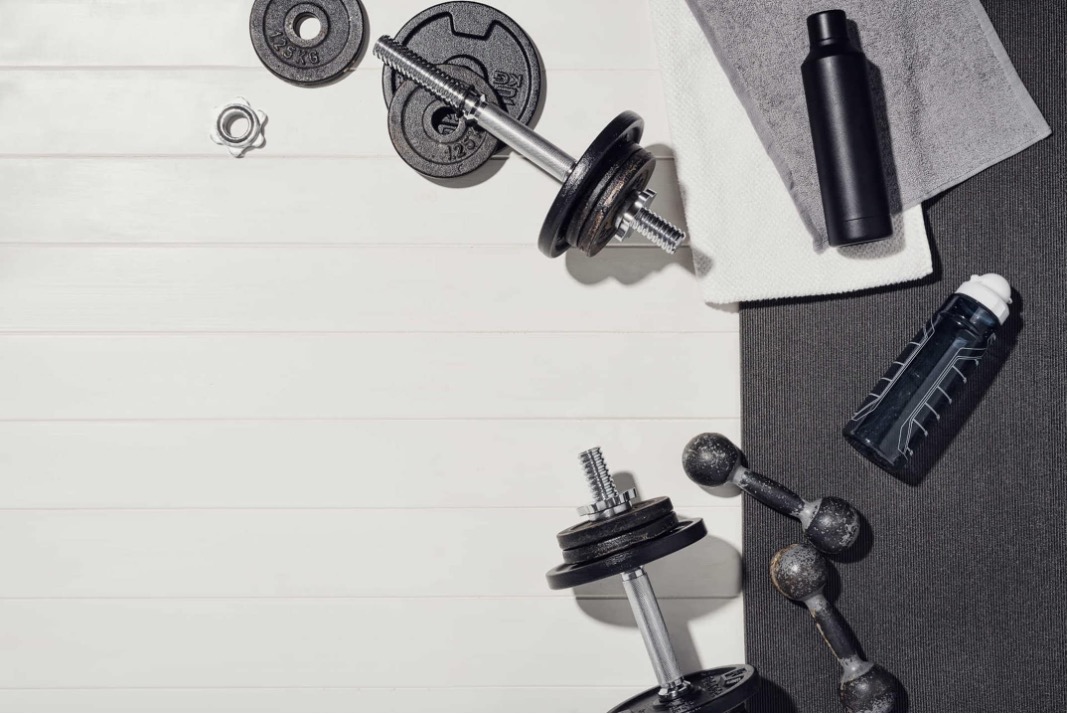 Home fitness equipment including dumbbells, weights, and water bottles