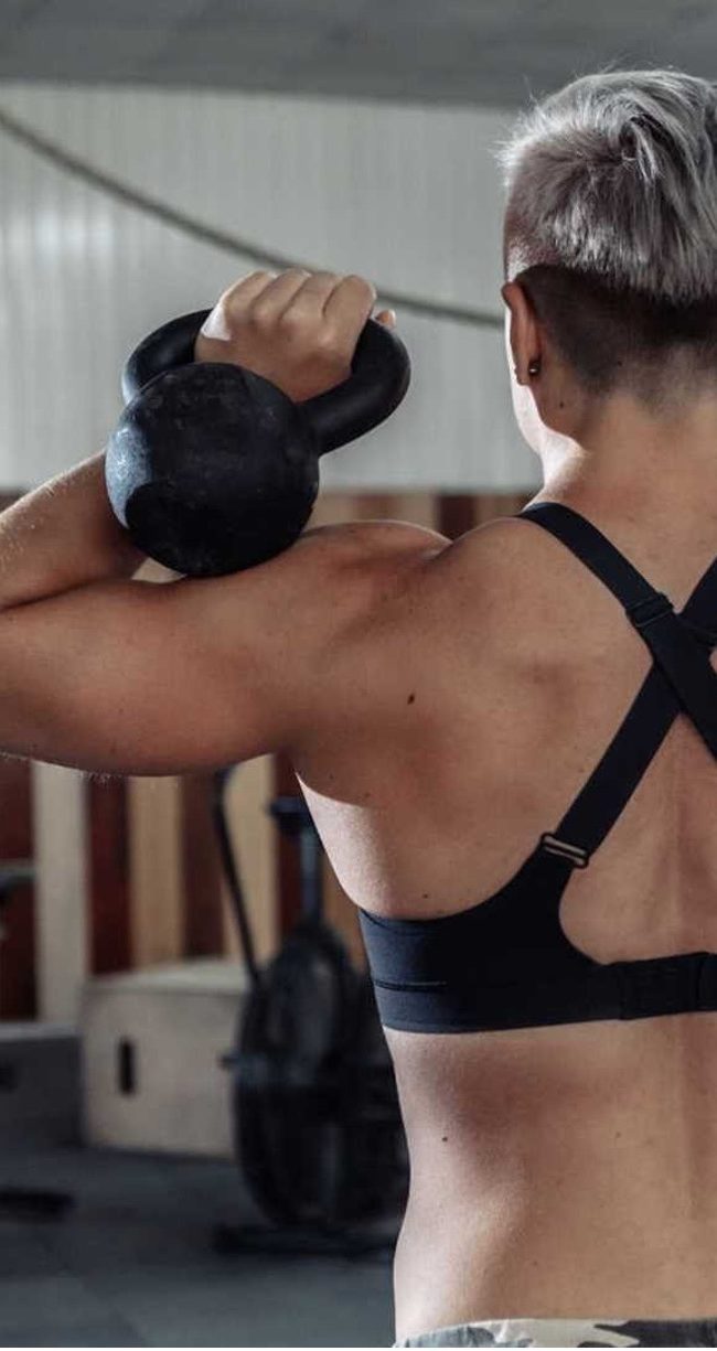 Woman holding kettlebells for full body strength training