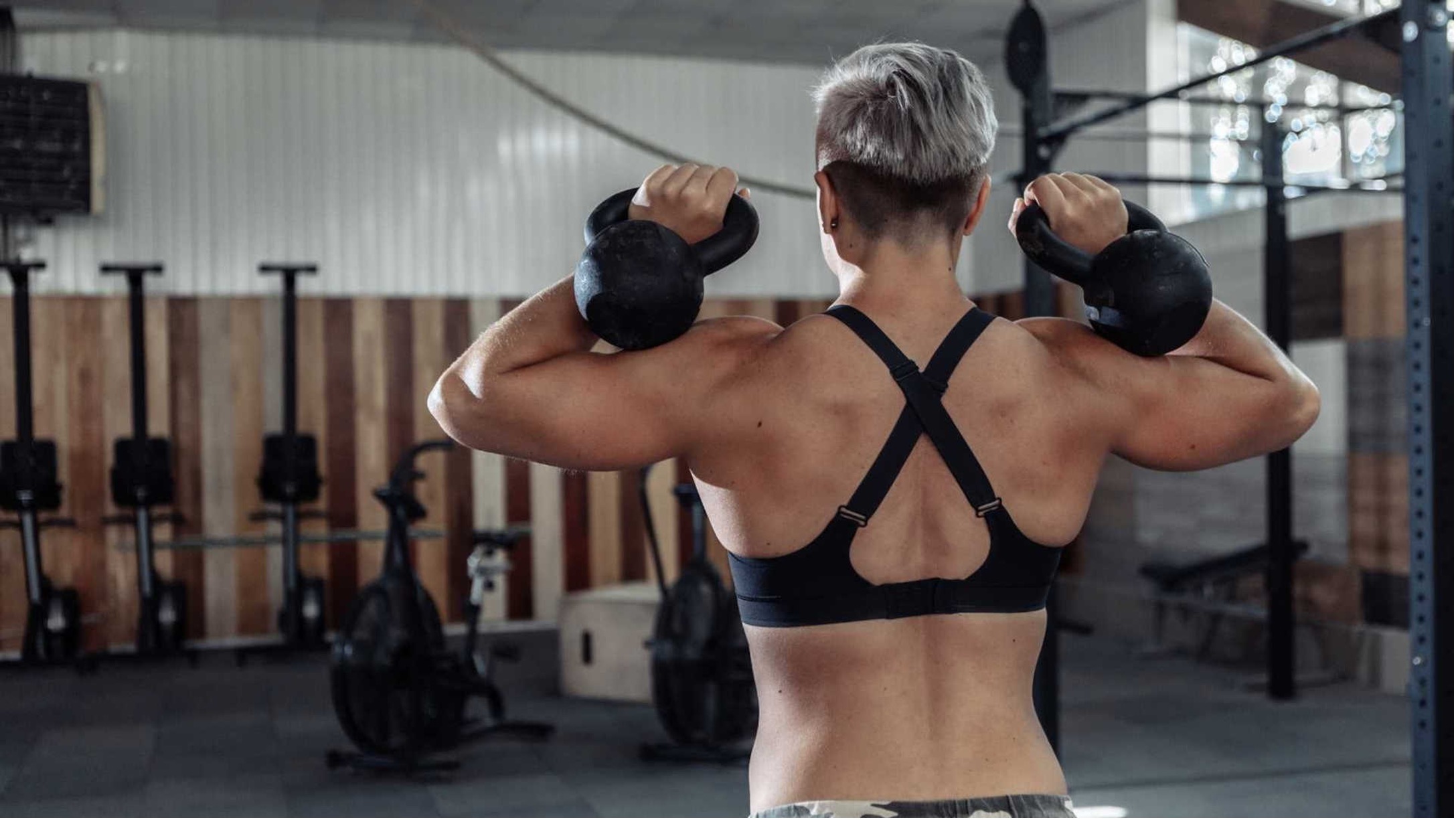 Woman holding kettlebells for full body strength training