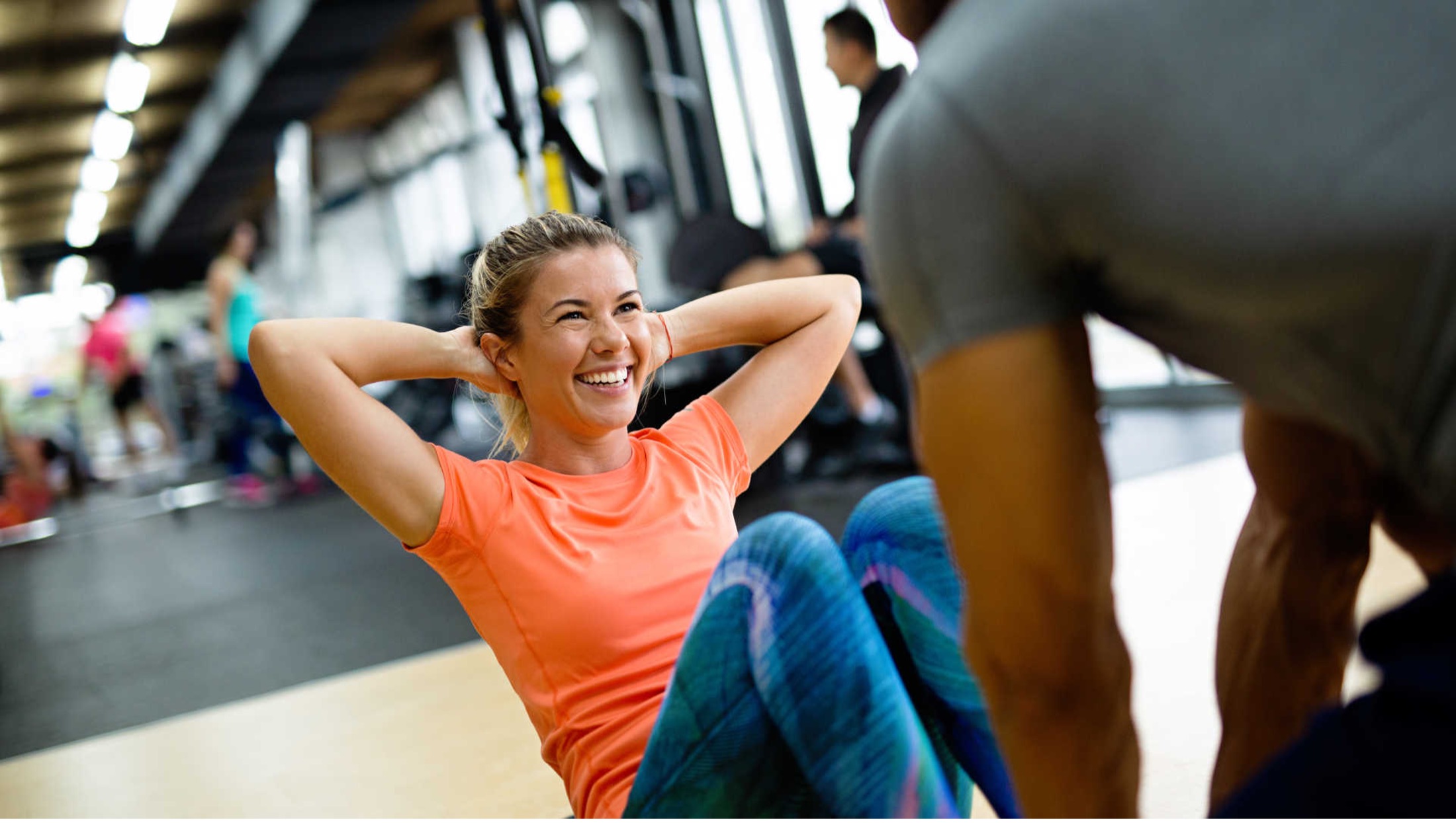 A woman at the gym, learning how to stay motivated to workout through personal coaching