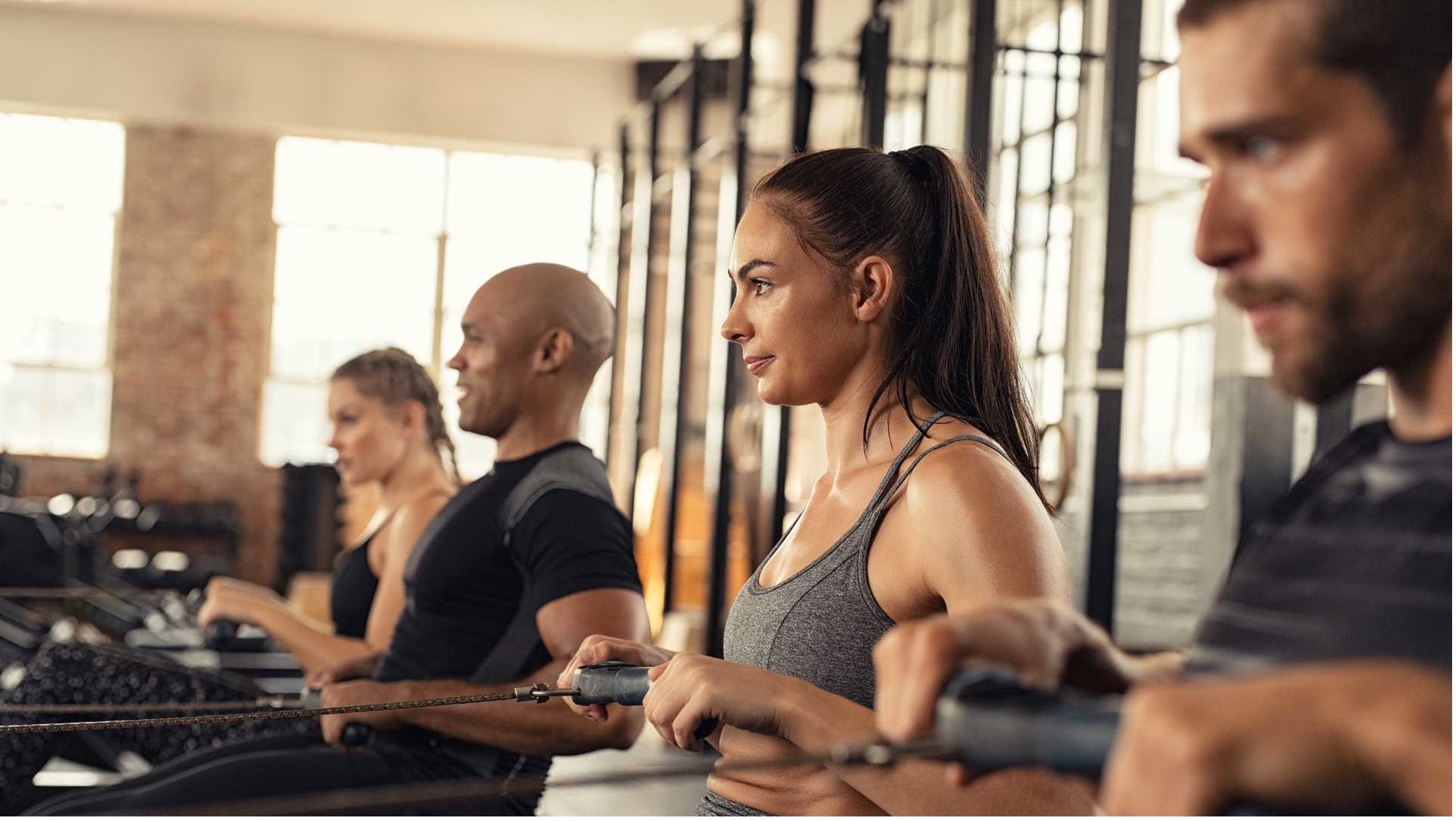 A group of people training and experiencing the benefits of rowing on a rowing machine