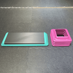 Cardio Equipment- (300*300)- Dismantled adjustable aerobic studio stepper (Black/Green/Pink) with adjustable heights placed on the side