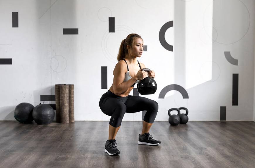 Intess woman squat kettlebell functional fitness